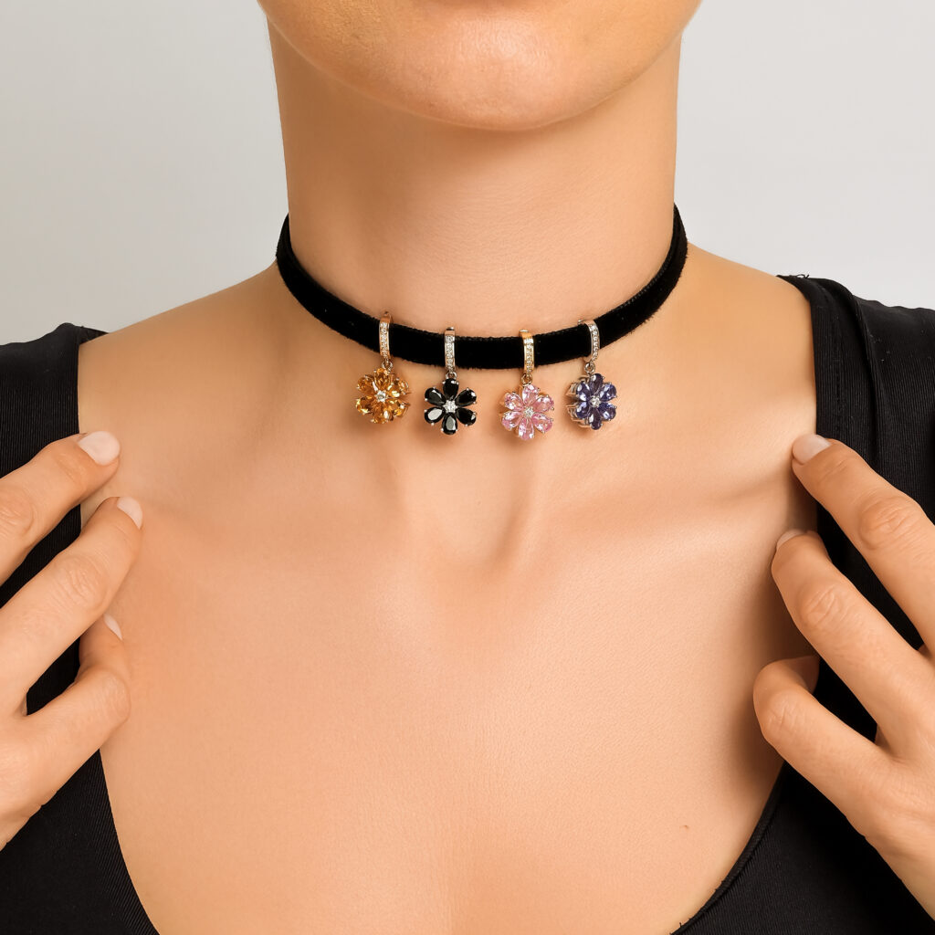Ottoman Garden pendant charms on a black velvet choker — citrine, black spinel, pink sapphire, and tanzanite flowers in gold, worn on neck