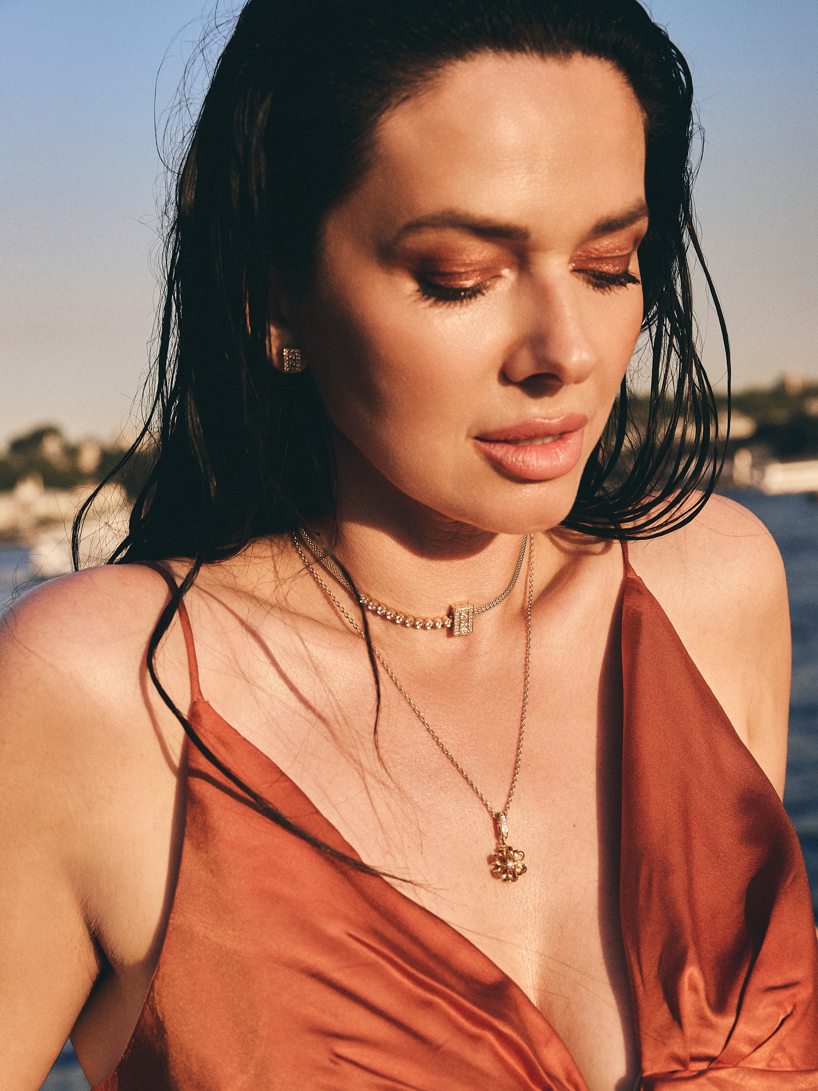 Jelena wearing layered Laleon jewelry, a diamond choker, fine chain necklace, and pendant, with matching stud earrings, golden hour by the Bosphorus