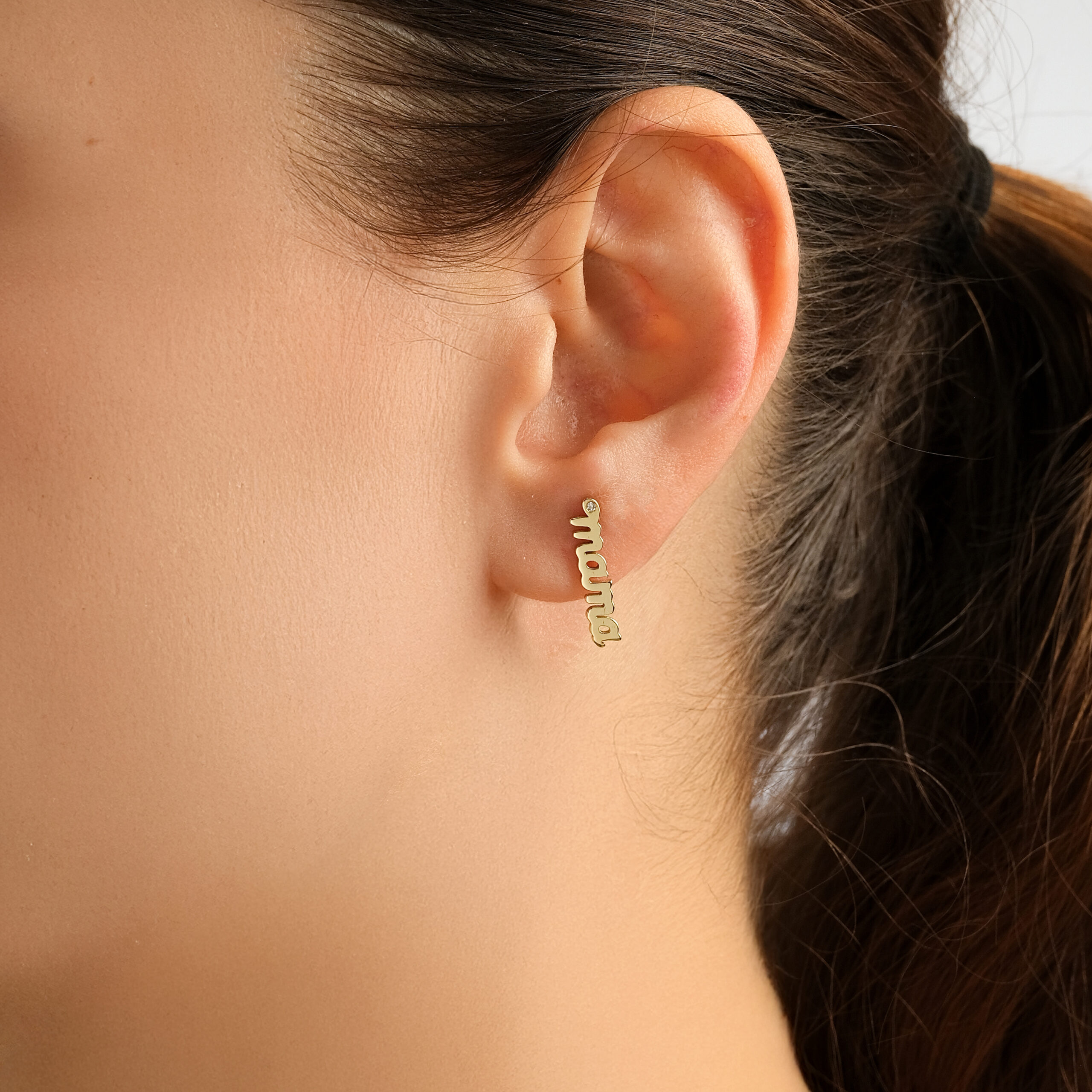 Mama Script Single Earring — the word mama in yellow gold script with a diamond accent, worn on ear